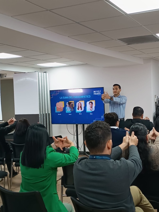 Un facilitador de Psicoanalizame guía un ejercicio práctico durante un workshop y el grupo lo replica